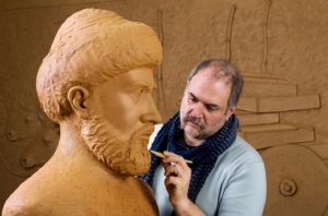 Sculptor working on brown bust and face