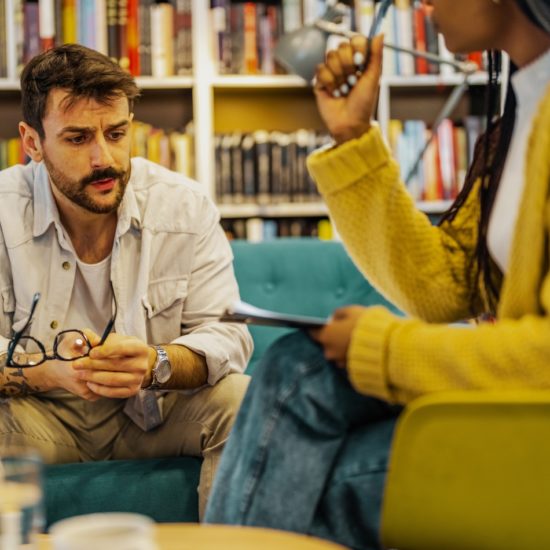 Psychotherapist in yellow in session with man